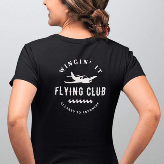 a female model showing the back of a black Wingin' It Flying Club T-Shirt - Aviator Apparel